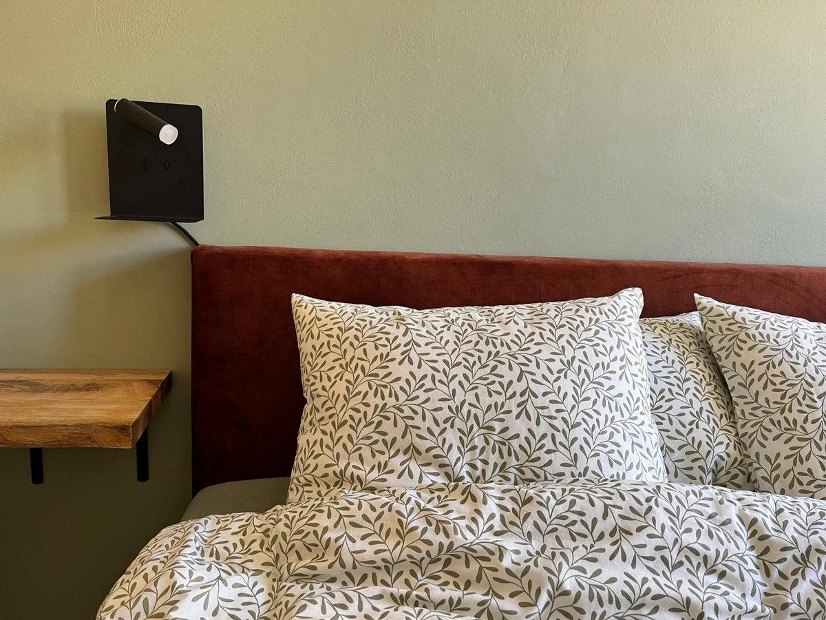 Slaapkamer met kingsize bed en houten hoofdeinde